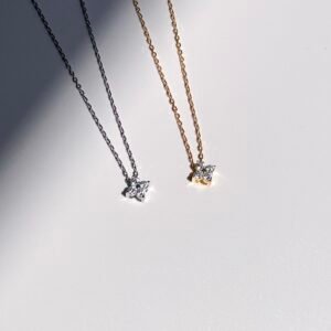 Four-leaf cubic zirconia necklace in silver and gold colours that spark under the sun