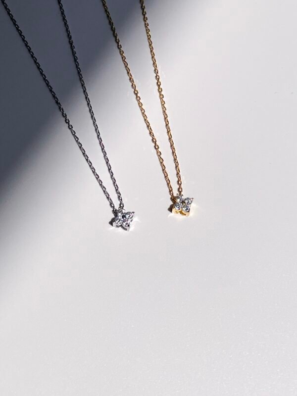 Four-leaf cubic zirconia necklace in silver and gold colours that spark under the sun