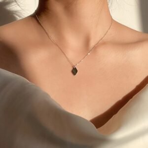 Model wearing minimal Silver Rhombus necklace under the sun, looking elegance and classy
