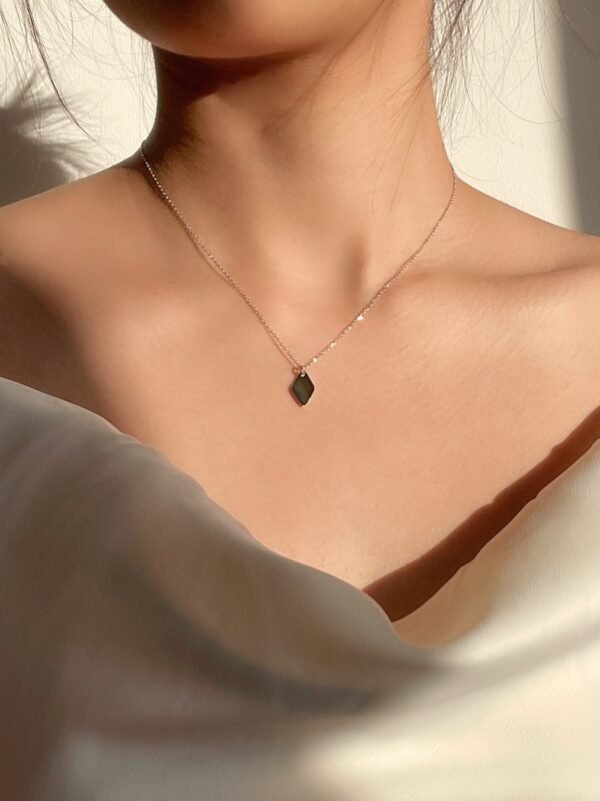 Model wearing minimal Silver Rhombus necklace under the sun, looking elegance and classy