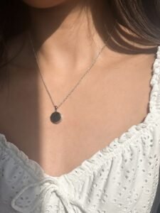 model wearing customised silver circle locket necklace, that the locket can carry photos with engraving at the front of the locket to carry memories