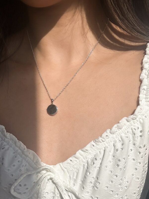 model wearing customised silver circle locket necklace, that the locket can carry photos with engraving at the front of the locket to carry memories